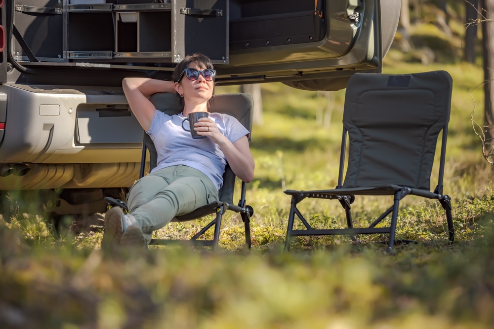 Personne détendue avec café près d'un van.