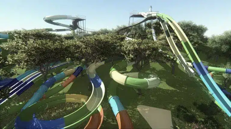 Toboggans colorés dans un parc aquatique arboré.